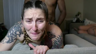 Cara de una zorra tatuada durante el sexo con un negro